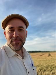 A man stands in front of a field