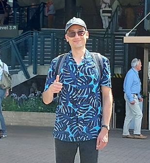 A man in a blue shirt gives a thumbs up