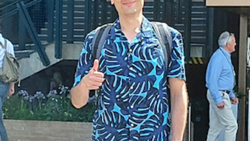 A man in a blue shirt gives a thumbs up