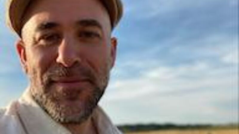 A man stands in front of a field