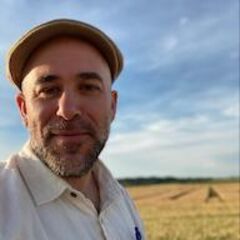 A man stands in front of a field