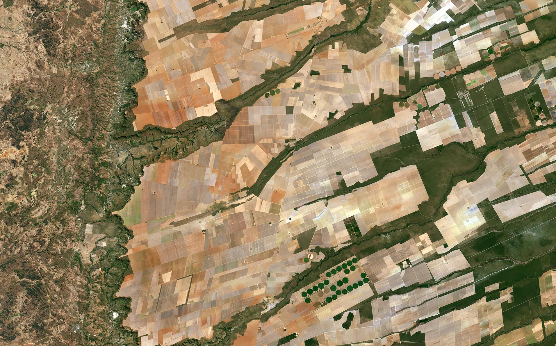 European Space Agency Sentinel 2A image of Brazilian farms from space. From ESA: "Here we can see a large, flat plateau blanked with fields benefiting from rich soils and an apparent abundance of water, before falling off into a green, hilly valley (left)